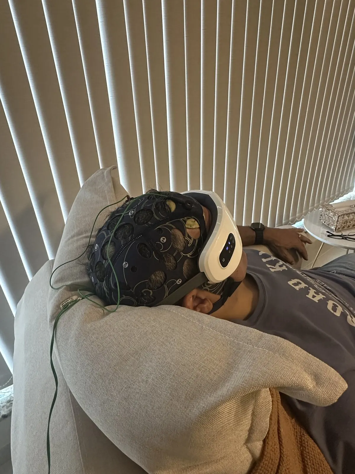 Paciente relaxando no sofá durante sessão de neuromodulação com touca de eletrodos