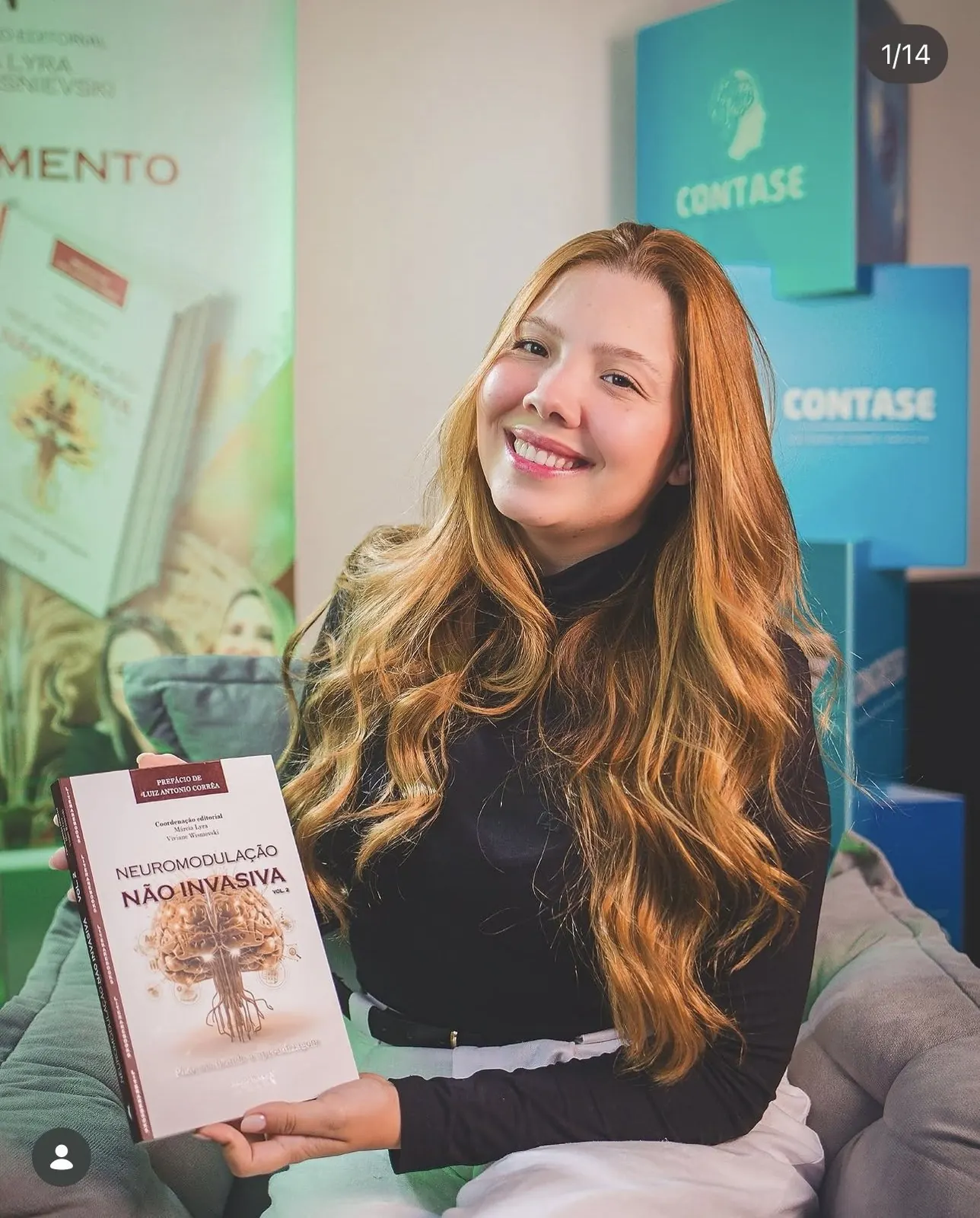 Brunna Vasconcellos sorrindo com o livro Neuromodulação Não Invasiva vol. 2
